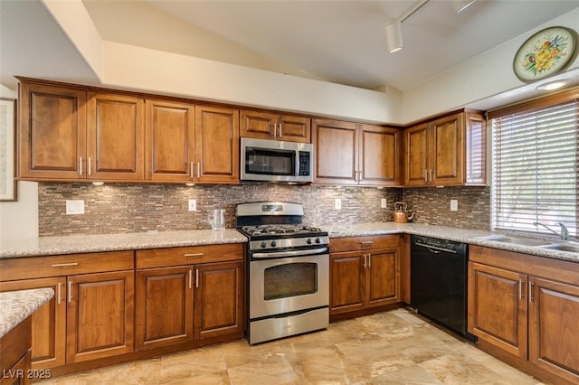 kitchen with backsplash, rail lighting, light stone counters, stainless steel appliances, and sink