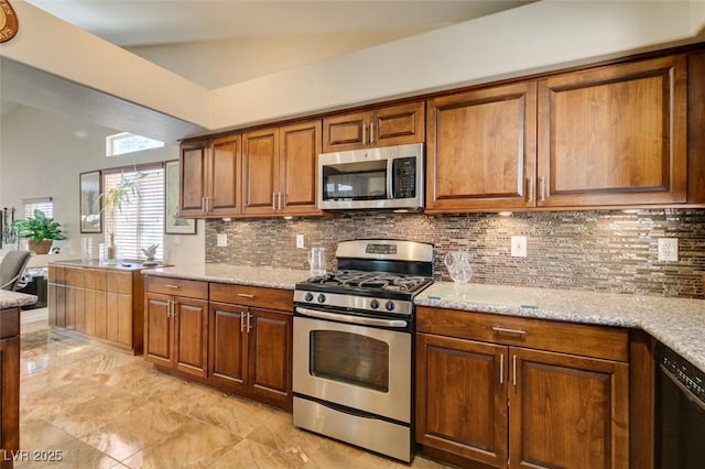 kitchen featuring decorative backsplash, light stone counters, and appliances with stainless steel finishes