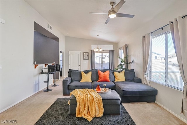 carpeted living room featuring lofted ceiling, plenty of natural light, and ceiling fan with notable chandelier