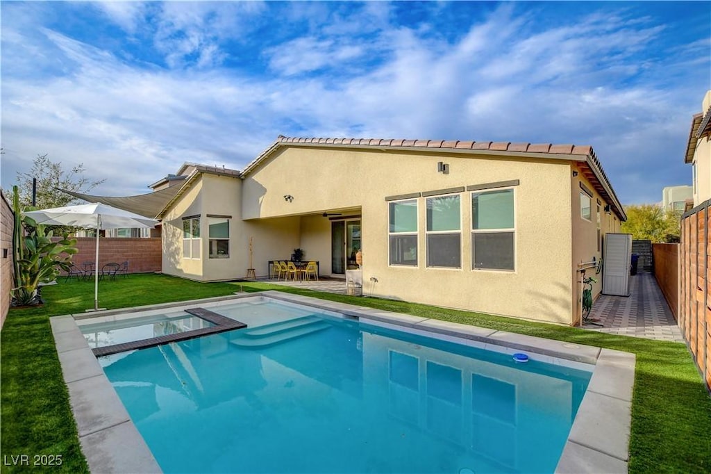 back of house featuring a yard and a fenced in pool