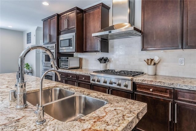 kitchen featuring sink, wall chimney range hood, stainless steel appliances, and tasteful backsplash