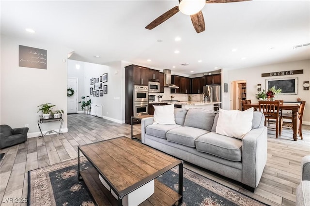 living room featuring ceiling fan and light wood-type flooring