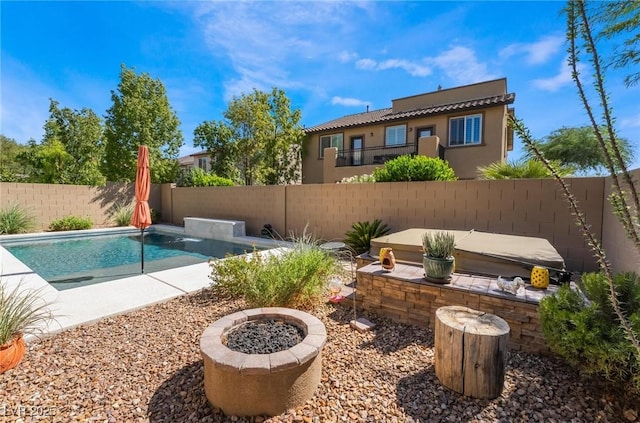 view of swimming pool featuring pool water feature and an outdoor fire pit