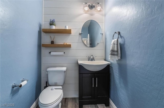 bathroom featuring vanity, hardwood / wood-style flooring, and toilet