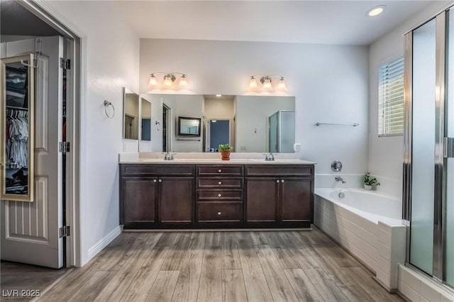 bathroom featuring hardwood / wood-style floors, vanity, and separate shower and tub