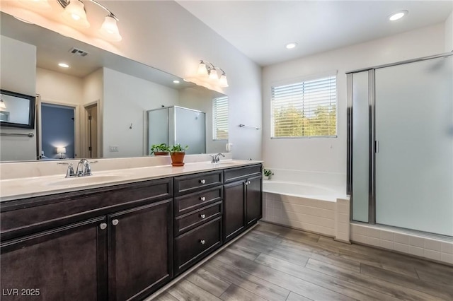 bathroom with shower with separate bathtub, vanity, and hardwood / wood-style flooring