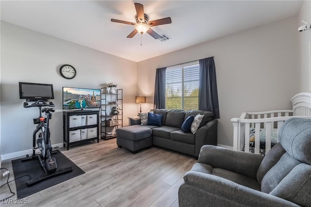 living room with light hardwood / wood-style floors and ceiling fan