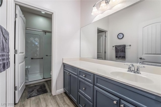 bathroom with wood-type flooring, vanity, toilet, and an enclosed shower