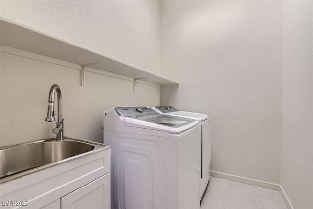 laundry room featuring cabinets, independent washer and dryer, sink, and light tile patterned floors