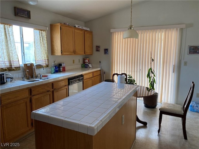 kitchen featuring stainless steel dishwasher, sink, decorative light fixtures, tile countertops, and a center island