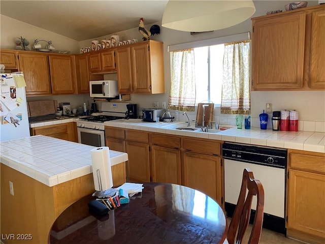 kitchen featuring tile counters, white appliances, and lofted ceiling