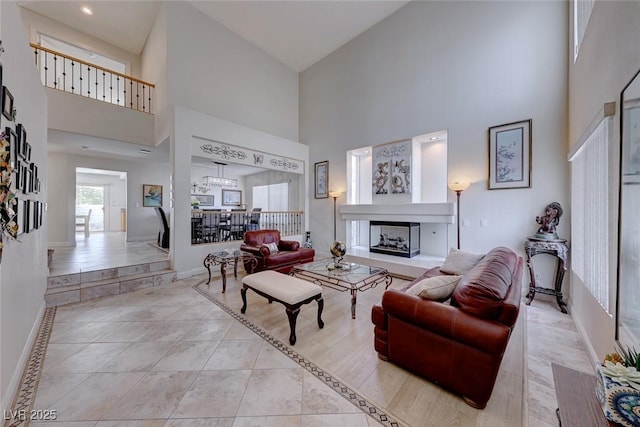 tiled living room featuring a multi sided fireplace and a high ceiling