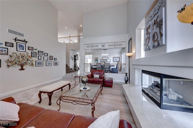 living room featuring a chandelier, a high ceiling, and plenty of natural light