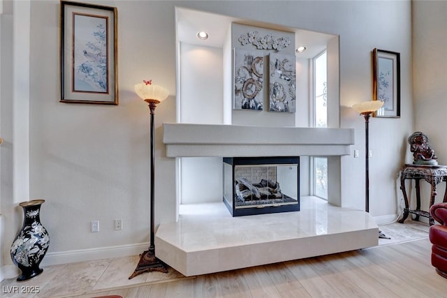 interior space featuring a multi sided fireplace and light hardwood / wood-style flooring