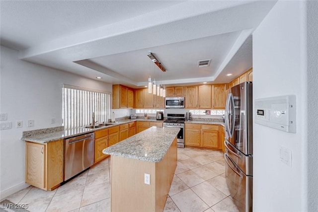 kitchen featuring light stone countertops, a center island, a raised ceiling, decorative light fixtures, and appliances with stainless steel finishes