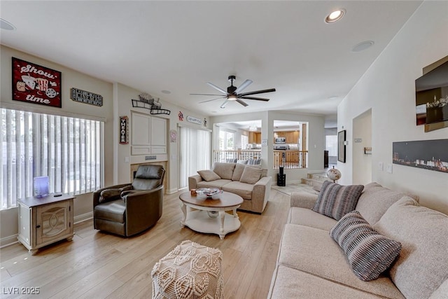 living room featuring light hardwood / wood-style flooring and ceiling fan