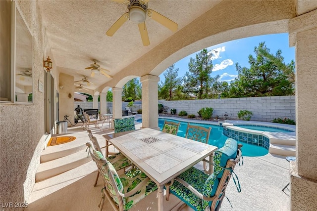 view of patio / terrace with a swimming pool with hot tub