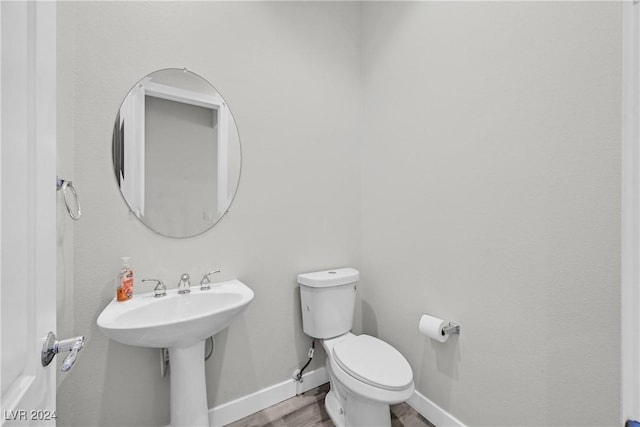 bathroom with hardwood / wood-style floors, toilet, and sink