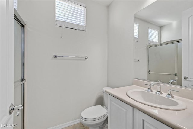 bathroom with a shower with door, vanity, and toilet