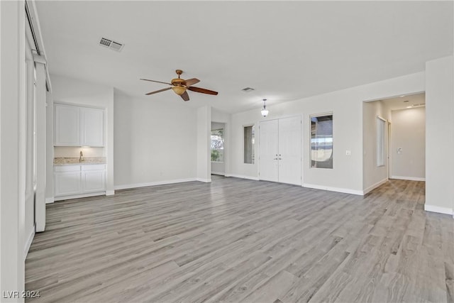 unfurnished living room with ceiling fan, plenty of natural light, and light wood-type flooring