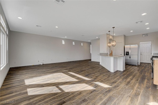 unfurnished living room with dark hardwood / wood-style flooring and an inviting chandelier