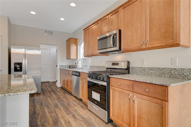 kitchen featuring sink, dark hardwood / wood-style flooring, light stone countertops, and stainless steel appliances