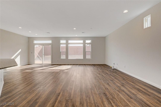 empty room featuring plenty of natural light and dark wood-type flooring