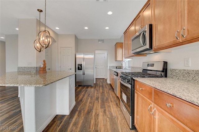 kitchen with light stone counters, stainless steel appliances, pendant lighting, an inviting chandelier, and a breakfast bar area