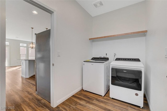 laundry room with washer and dryer and dark wood-type flooring