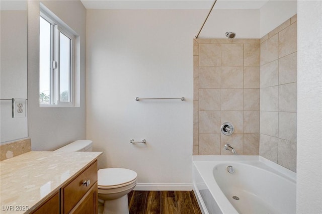 full bathroom with hardwood / wood-style flooring, vanity, toilet, and tiled shower / bath