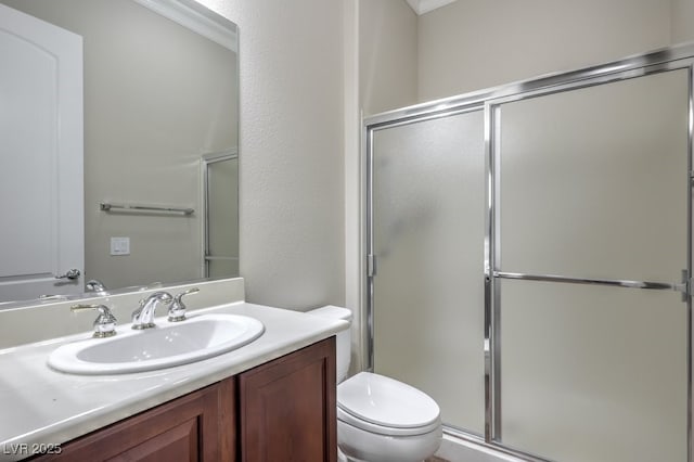 bathroom with vanity, toilet, ornamental molding, and walk in shower