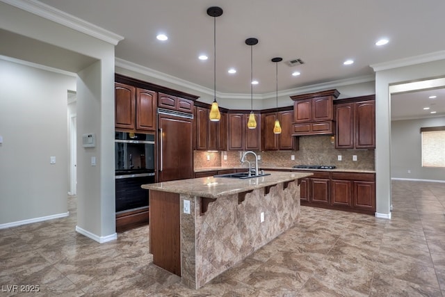 kitchen with sink, paneled refrigerator, crown molding, an island with sink, and dark brown cabinets