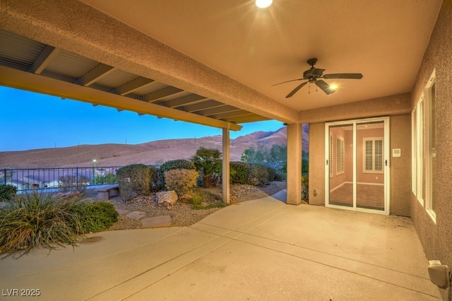 view of patio / terrace with a mountain view and ceiling fan