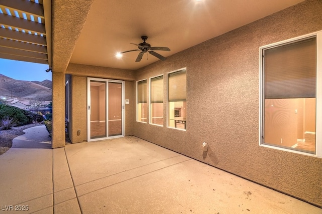 view of patio / terrace featuring ceiling fan and a mountain view