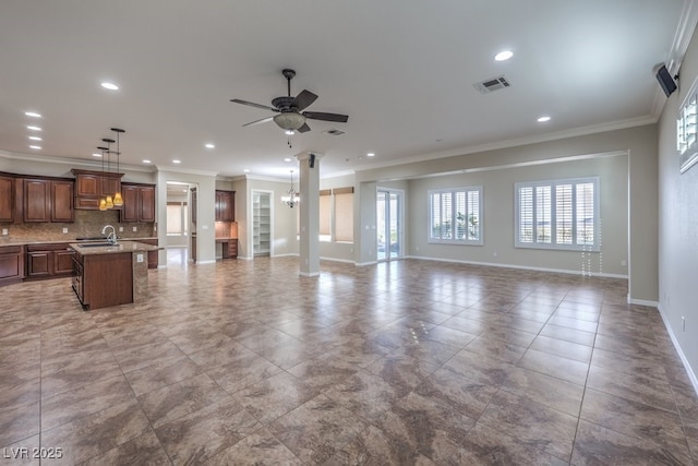 living room with ceiling fan with notable chandelier, crown molding, and sink