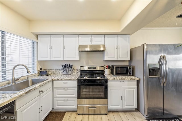 kitchen with sink, white cabinets, exhaust hood, and appliances with stainless steel finishes