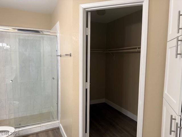 bathroom with hardwood / wood-style flooring, toilet, and walk in shower