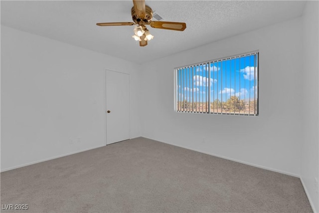 carpeted spare room featuring a textured ceiling and ceiling fan