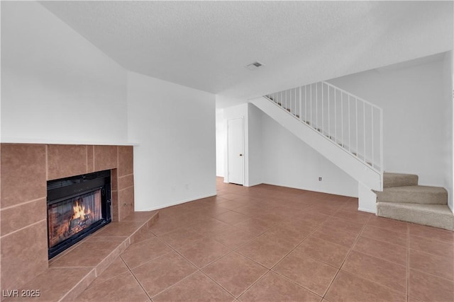 unfurnished living room featuring tile patterned floors, a fireplace, and a textured ceiling