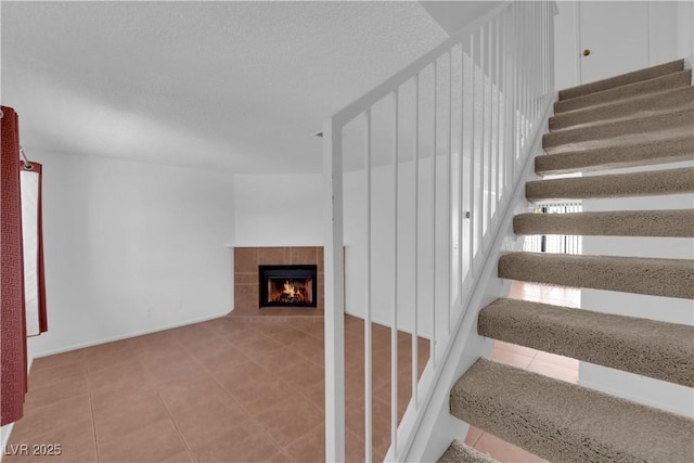 stairway featuring a tile fireplace