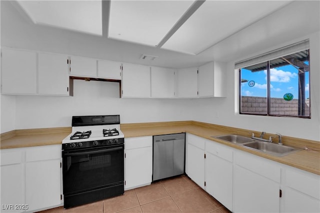 kitchen with white cabinets, sink, light tile patterned floors, dishwasher, and black gas range