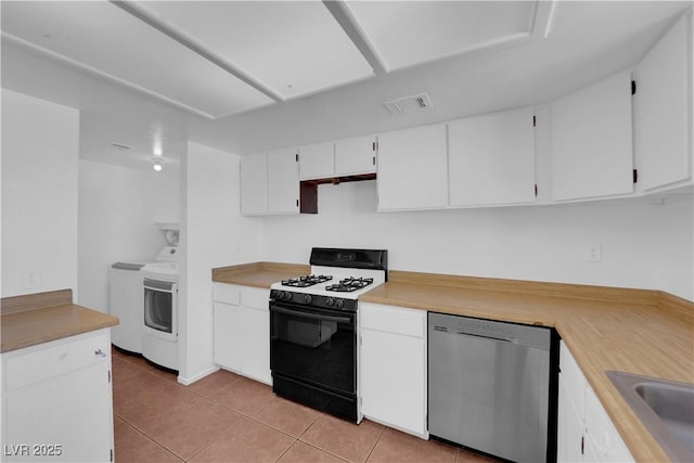 kitchen featuring dishwasher, white cabinets, washing machine and dryer, white gas range, and light tile patterned flooring