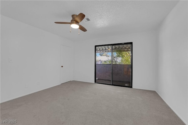 empty room featuring ceiling fan, light colored carpet, and a textured ceiling