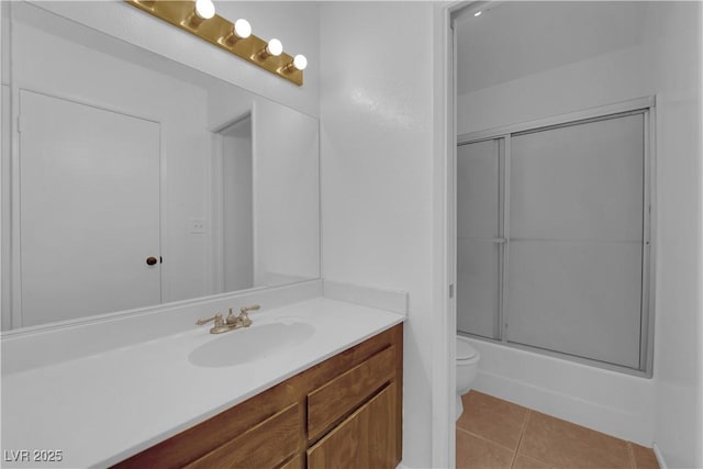 full bathroom featuring toilet, vanity, tile patterned floors, and bath / shower combo with glass door