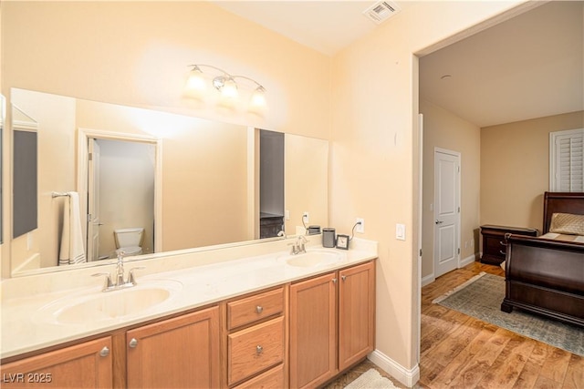 bathroom with hardwood / wood-style flooring, vanity, and toilet