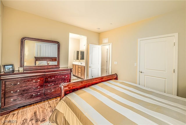 bedroom featuring connected bathroom and hardwood / wood-style floors