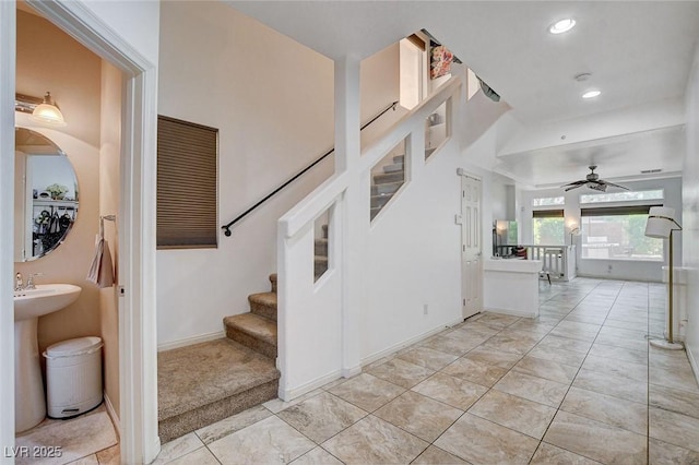 stairway with tile patterned floors and ceiling fan