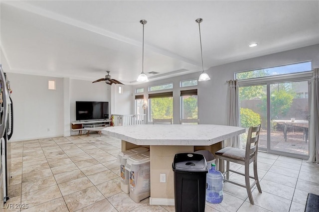 kitchen with decorative light fixtures, a kitchen island, light tile patterned floors, and ceiling fan