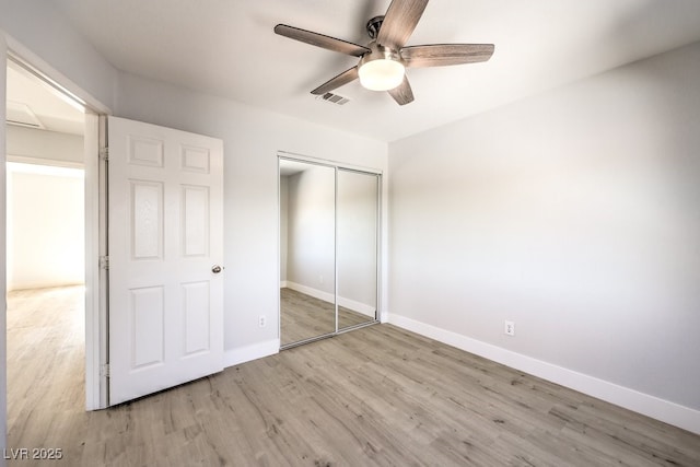 unfurnished bedroom featuring ceiling fan, a closet, and light hardwood / wood-style floors