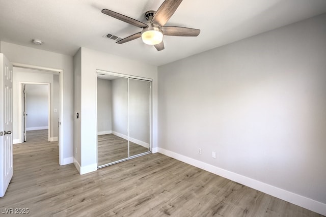 unfurnished bedroom with ceiling fan, light hardwood / wood-style flooring, and a closet